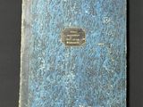 an old book sitting on top of a table next to a black table