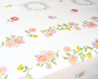 a bed with a white sheet with colorful flowers on it