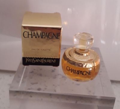 une bouteille de champagne à côté d'un coffret de parfum