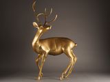 gold deer statue on a grey background with a gray background