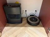une cuve de cuisson et un aspirateur posés par terre dans un coin de la pièce