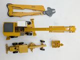 a yellow construction vehicle and a wren on a white surface