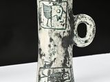 a white vase with a black and white design on it