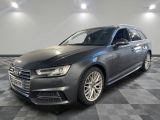 a grey audi is parked on a checkered floor in a garage