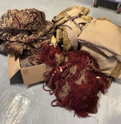 un tas de vêtements par terre, à côté d'un carton