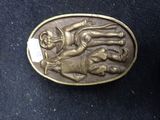 brass belt buckle depicting a man on a horse and a dog