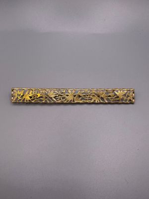 a close up of a gold plated metal object on a gray surface