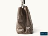 the large brown bag is sitting on a white surface