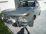 a silver car parked in front of a garage