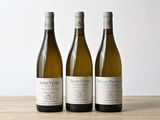 trois bouteilles de vin posées sur une table en bois