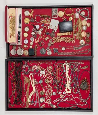 a red box filled with lots of jewelry on a white surface