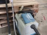 un aspirateur posé par terre à côté d'une palette