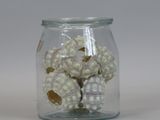 a glass jar with a bunch of small balls inside of it