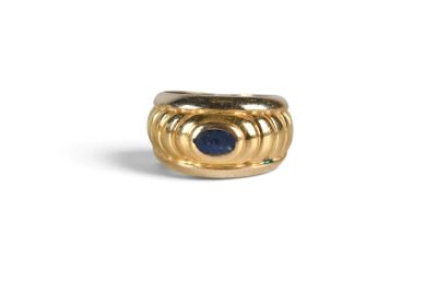 a close up of a gold ring with a blue stone
