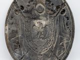 a close up of a metal plate with a coat of arms on it