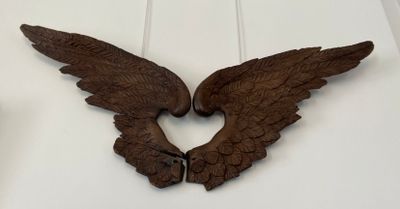 two wooden wings hanging on the wall next to each other