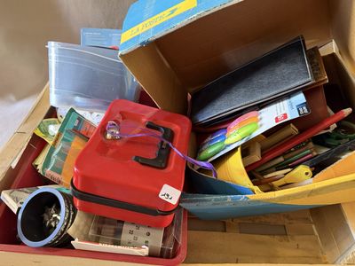 une boîte remplie de fournitures scolaires posée sur une table