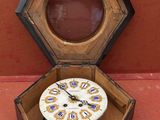 une horloge à l'intérieur d'une boîte en bois posée sur une surface rouge