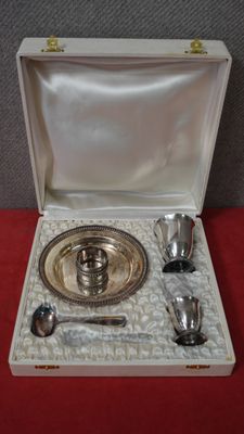 un plateau en argent avec des cuillères, le tout rangé dans une boîte