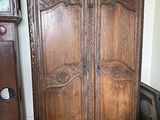 une grande armoire en bois surmontée d'une horloge