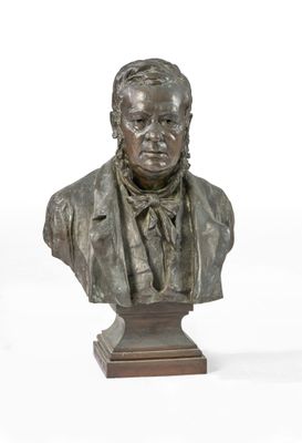 statue représentant le buste d'un homme en costume-cravate, posée sur un socle en bois