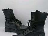 des bottes militaires en cuir noir à lacets et à semelles en caoutchouc, sur fond blanc