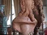 a bust of a woman sitting on a table in front of a mirror