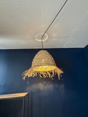 a straw hat hanging from the ceiling of a blue room
