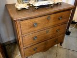 a small chest of drawers with a clock on top