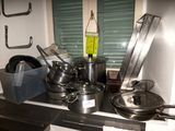 de nombreuses casseroles et poêles sur la cuisinière dans la cuisine