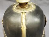 a small black and gold object on a white surface
