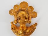 une image représentant une figurine en or sur fond blanc