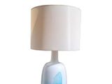 une lampe de table blanche ornée d'un motif bleu