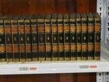 de nombreux livres qui se trouvent sur une étagère dans une bibliothèque