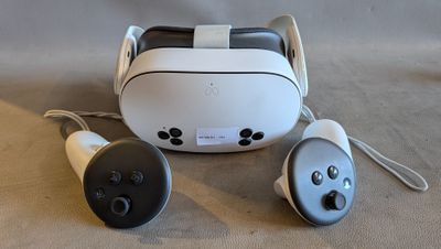 a white and black vr headset and two remote controls
