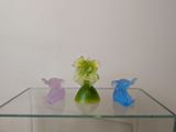 three glass vases sitting on top of a glass table