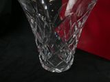 a glass vase with a spoon in it sitting on a table
