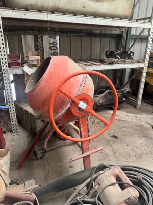 une bétonnière rangée dans un garage avec d'autres outils