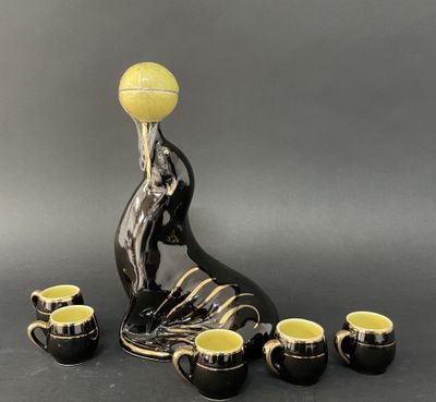 un vase noir et jaune contenant une balle de tennis