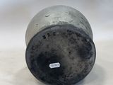 an old metal cup sitting on top of a white table