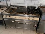 a dirty kitchen with a stove and oven in it