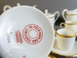 une tasse et une soucoupe posées sur une table, à côté d'autres tasses et soucoupes