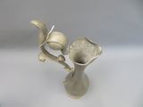 a silver vase with two flowers in it on a table