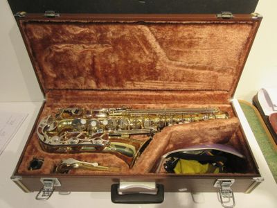 un étui contenant un saxophone, posé sur une table