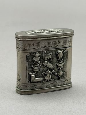 une image représentant une petite boîte en argent posée sur une table