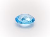 a close up of a blue topazte gems on a white surface