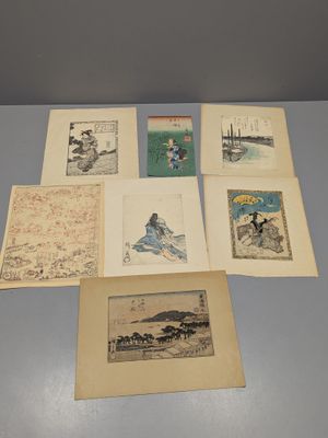 plusieurs anciennes estampes japonaises posées sur une table dans une pièce