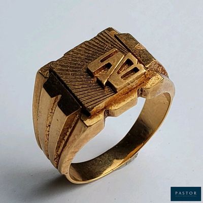 une bague en or ornée d'une croix, posée sur un fond blanc