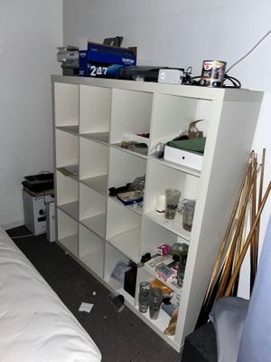 un lit blanc dans une chambre avec une bibliothèque