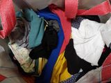 a bag full of clothes that is sitting on the floor